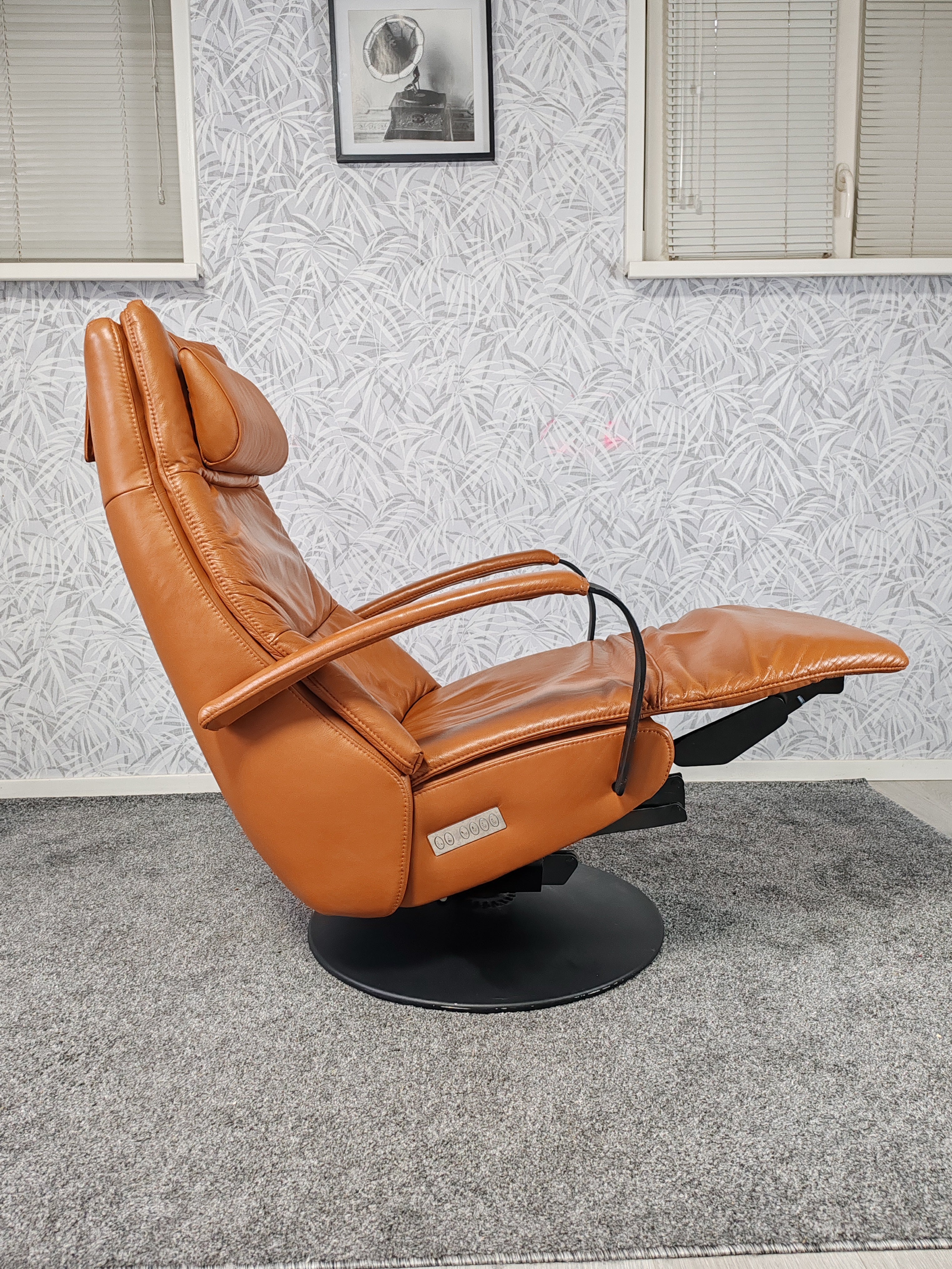 Prominent Humberto Tan leren sta op stoel relax fauteuil