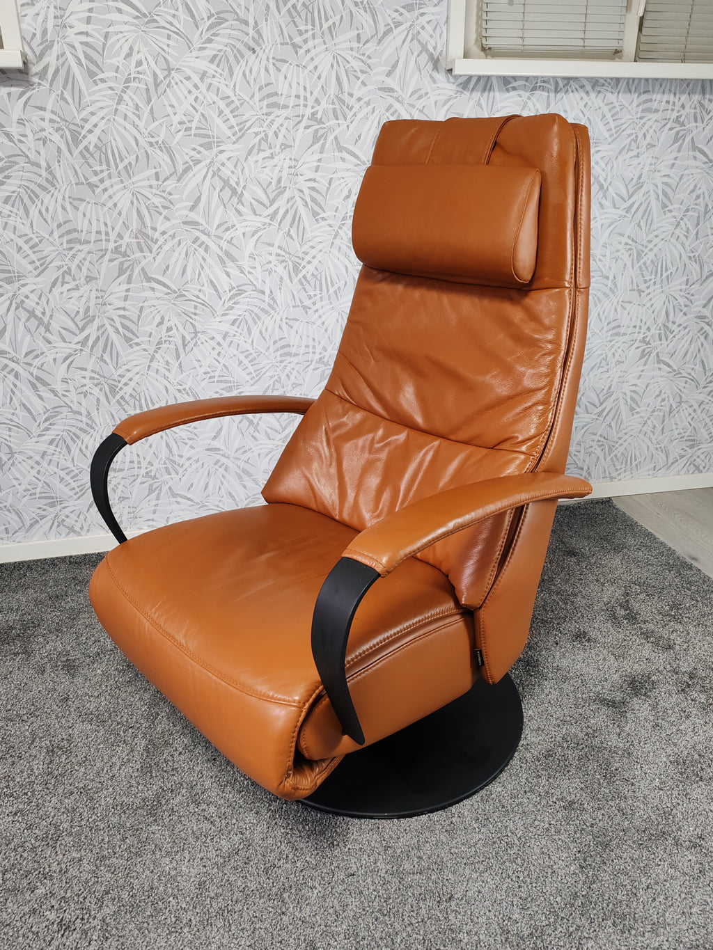 Prominent Humberto Tan leren sta op stoel relax fauteuil