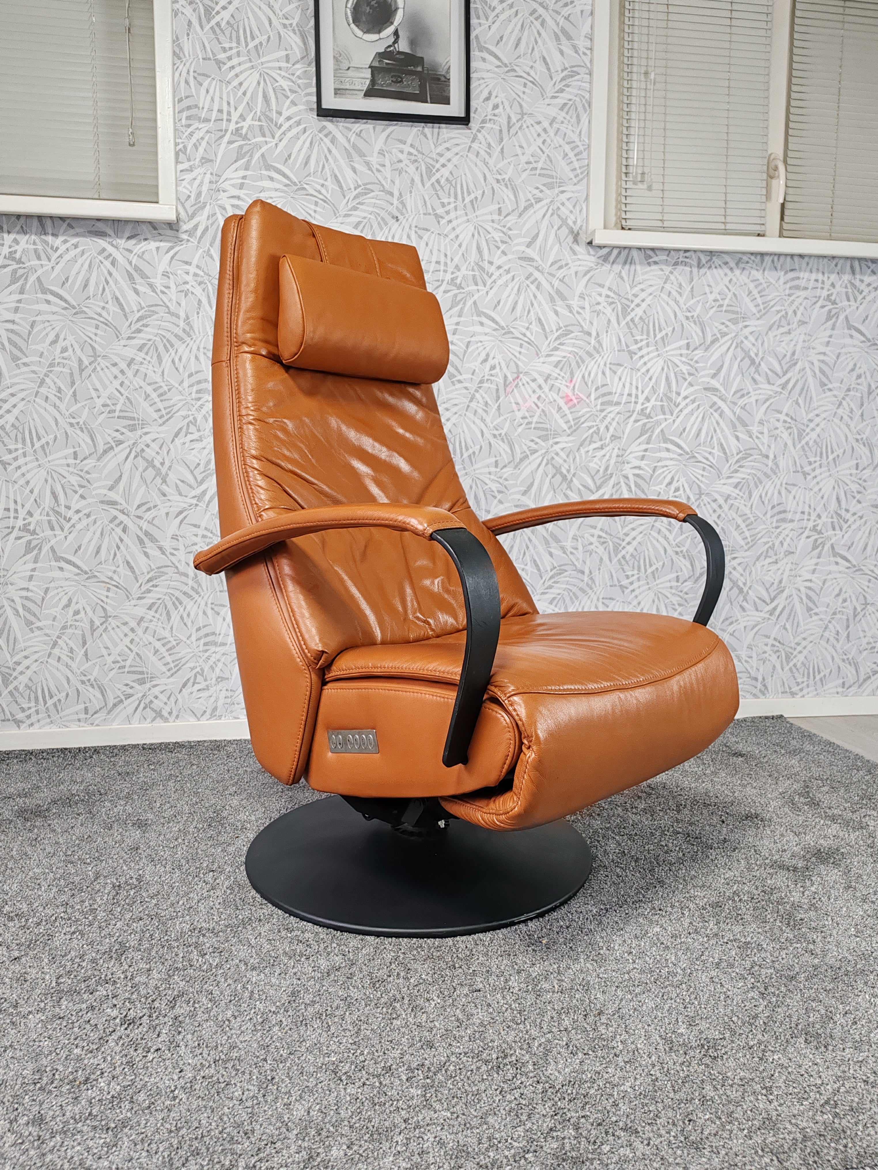 Prominent Humberto Tan leren sta op stoel relax fauteuil