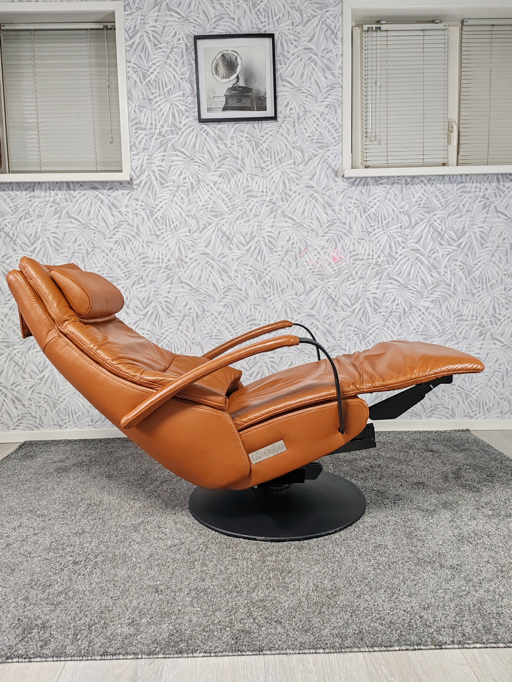 Prominent Humberto Tan leren sta op stoel relax fauteuil