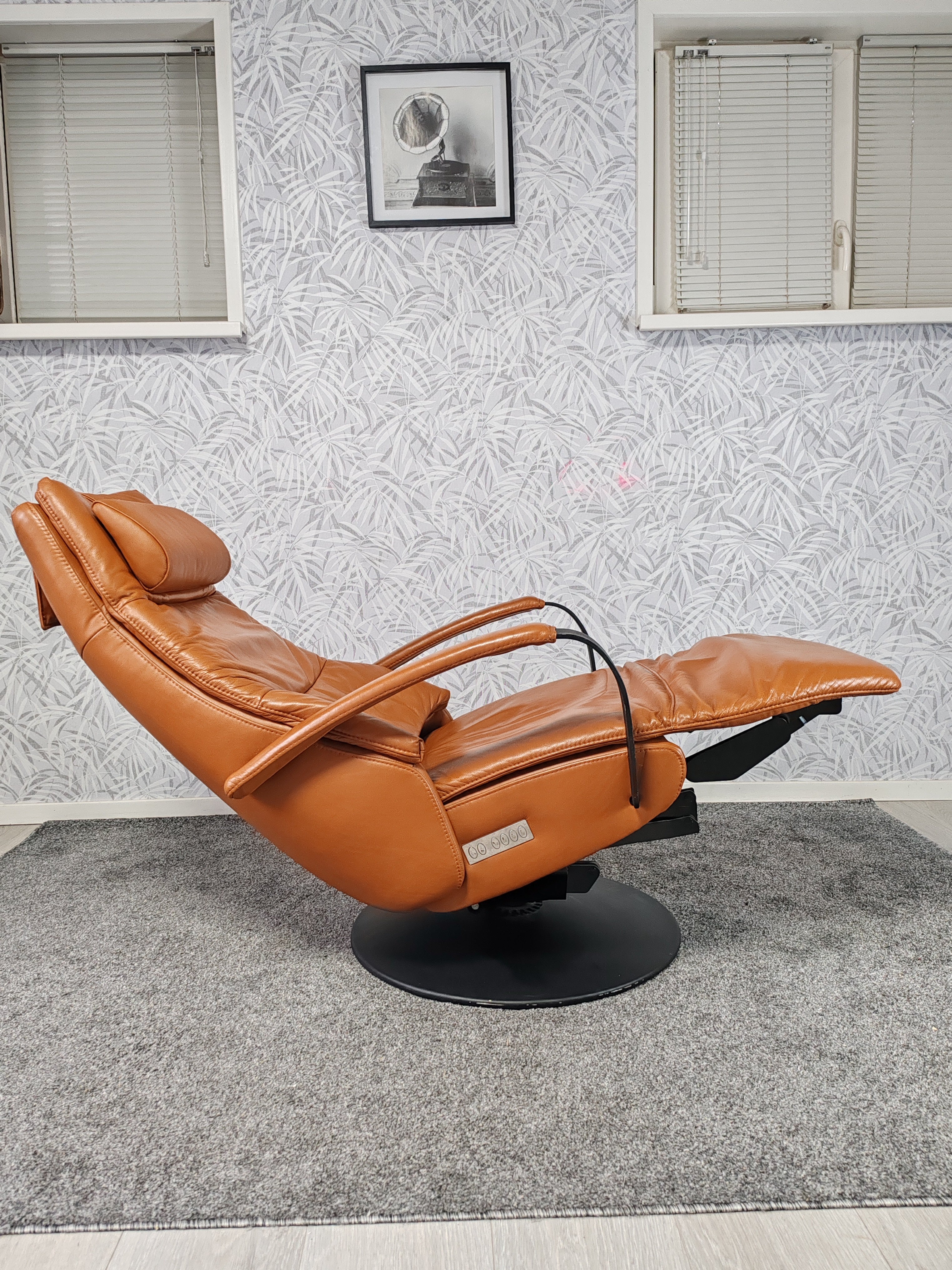 Prominent Humberto Tan leren sta op stoel relax fauteuil
