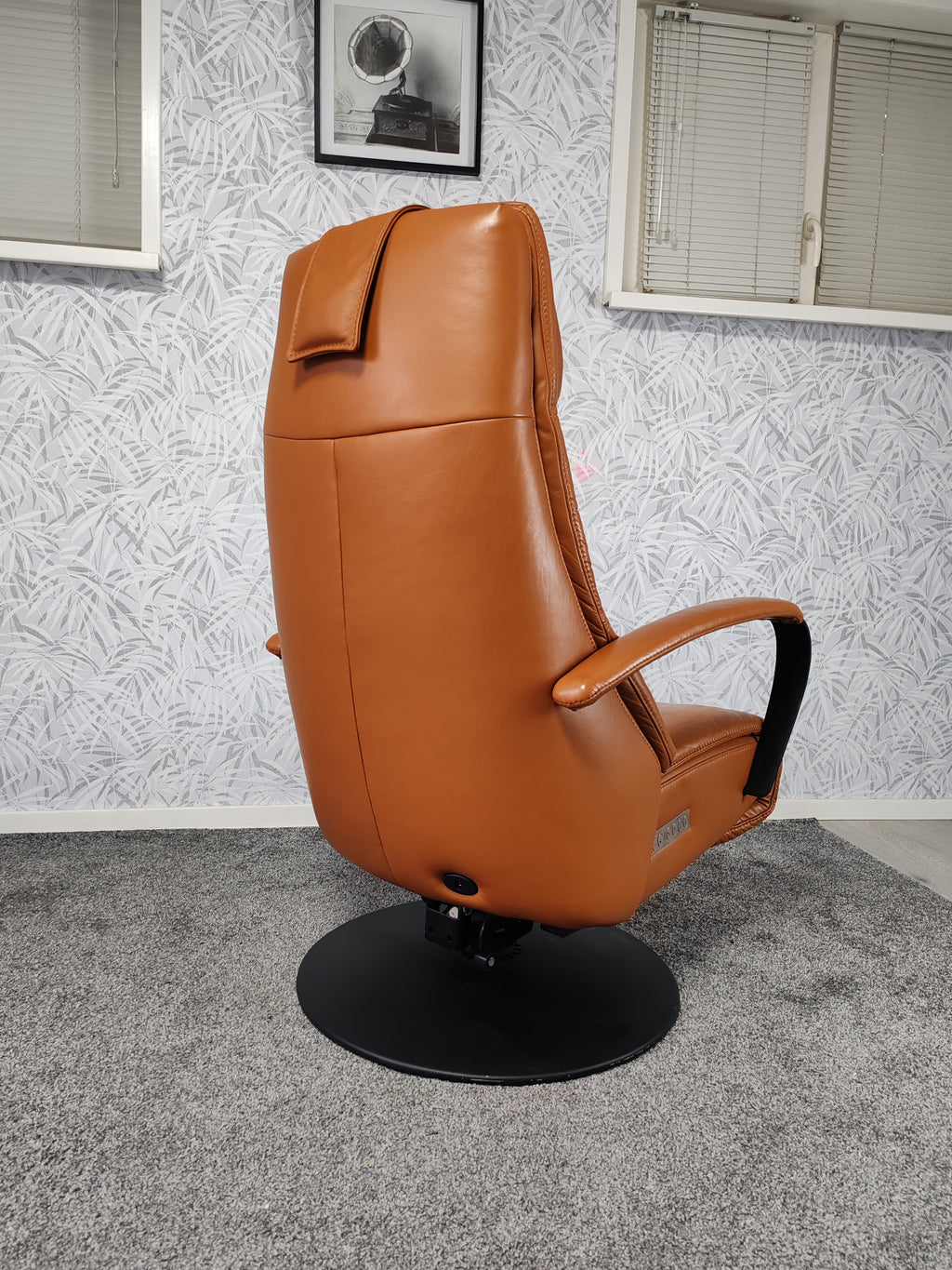 Prominent Humberto Tan leren sta op stoel relax fauteuil