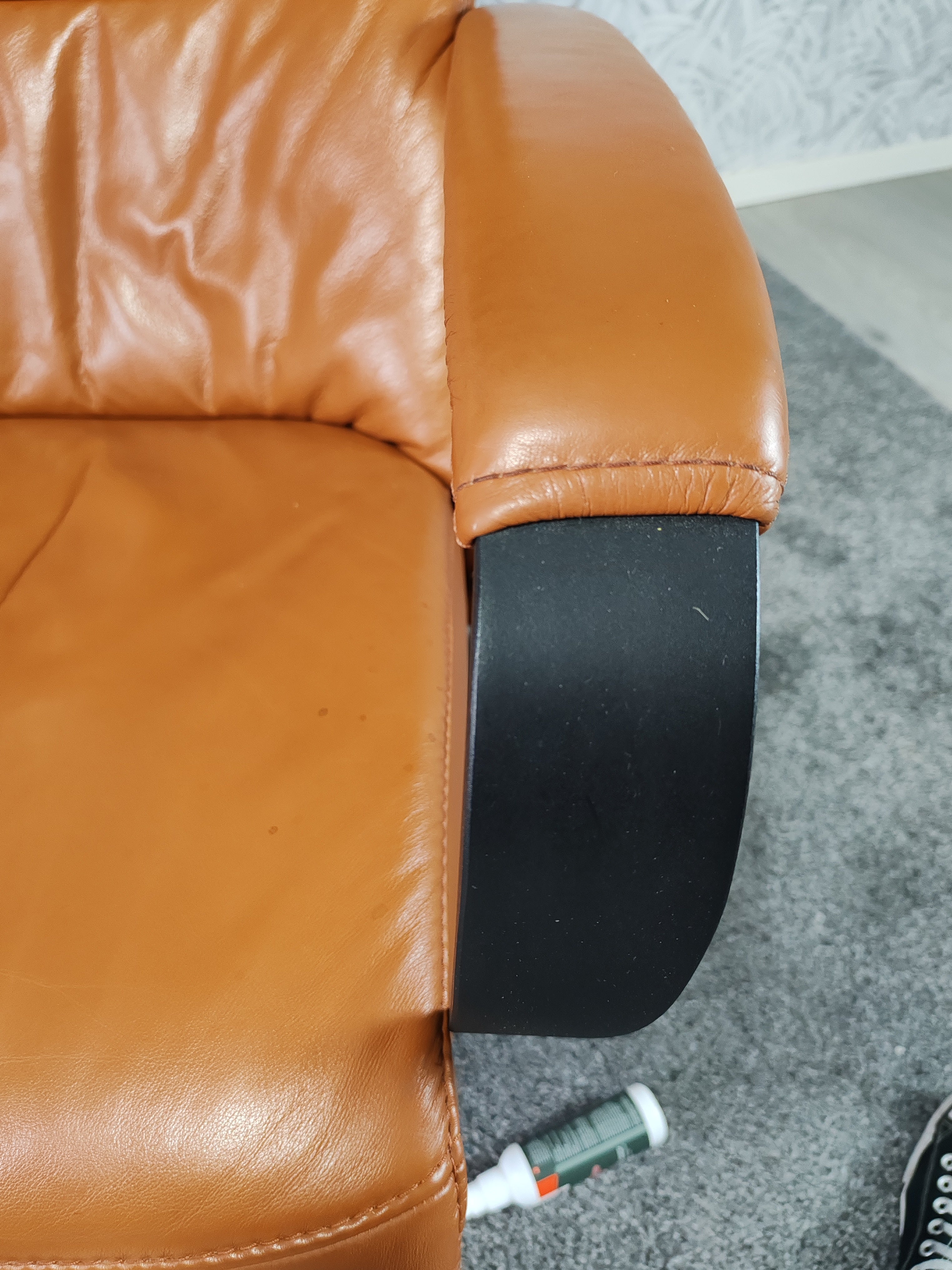 Prominent Humberto Tan leren sta op stoel relax fauteuil